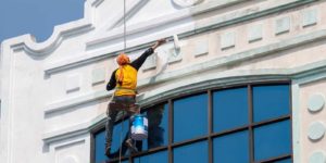 Painting contractor performing commercial painting services on building