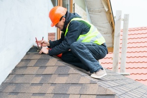 Roofing contractor who offers a workmanship warranty working on a roof