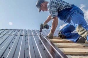 man installing metal roof