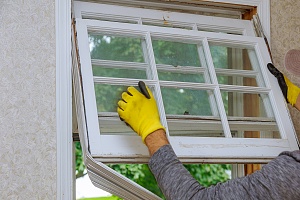 window replacement professional taking out an old window from a home