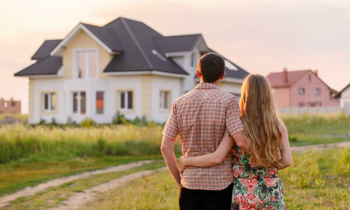 rear view of young couple looking at their new house